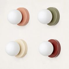 four different colored knobs mounted to the side of a wall with one white ball