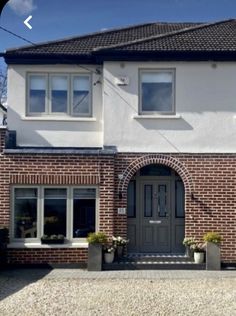 a large white brick house with two windows