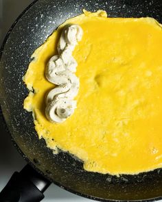 an omelet is being cooked in a frying pan