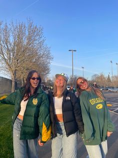 three girls are standing in the parking lot