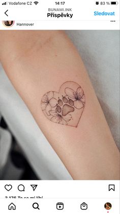 a heart shaped tattoo with an animal's paw and flower petals on the arm