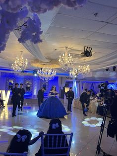 a group of people standing in a room with chandeliers