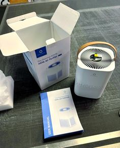 an air purifier sitting on top of a table next to a box