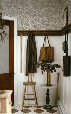 a wooden chair sitting next to a table with a brown bag on top of it