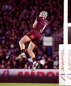 a rugby player jumping in the air to catch a ball