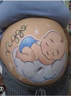 a pregnant woman with her belly painted to look like a baby sleeping on top of a cloud