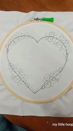 a heart - shaped embroidery project is shown on a piece of paper with a green marker