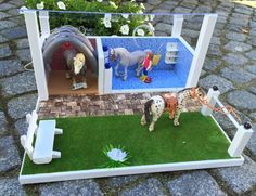 a miniature horse stable with two horses and a dog in the back yard, on display