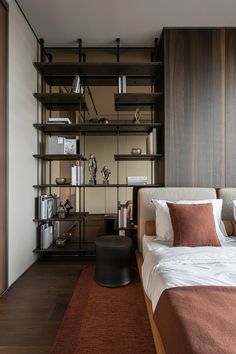 a bed sitting next to a book shelf filled with books