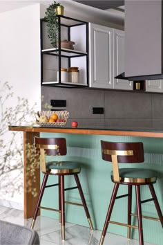 two bar stools sitting in front of a kitchen counter