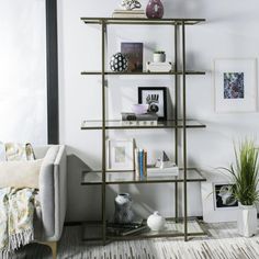 a shelf with books and pictures on it in the corner of a room next to a couch