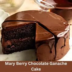 there is a chocolate ganache cake with one slice cut out and ready to be eaten