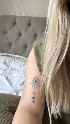 a woman's arm with an eye tattoo on the left side of her body