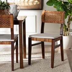 two chairs sitting next to each other in front of a table and potted plant