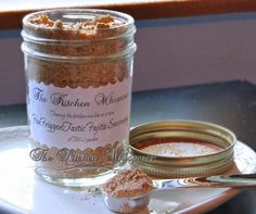 a glass jar filled with powdered sugar on top of a plate next to a spoon