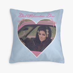 a heart shaped pillow with the image of a woman in a car