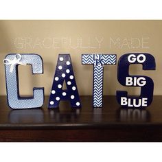 the letters are made out of wood and have polka dots on them, as well as bows