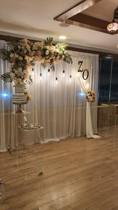 a room that has some flowers on the wall and curtains behind it with lights hanging from the ceiling