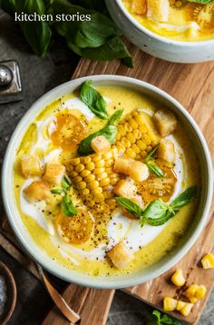 two bowls filled with soup and garnished with green leaves