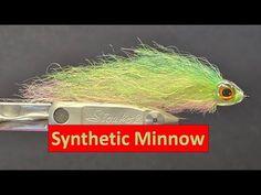 a green and yellow fly with the words synthetic minnow on it