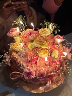 a birthday cake with candles and flowers on it