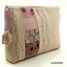 a purse with patchwork and flowers on the inside is sitting on a white surface