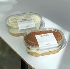 two desserts with labels on them sitting on a table