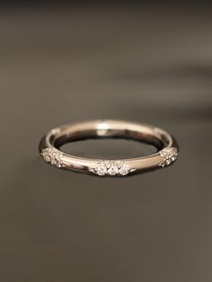 a wedding ring with three diamonds on it sitting on a table in front of a black background