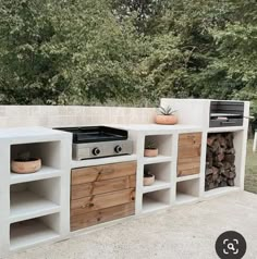 an outdoor kitchen made out of cinder blocks and wooden cabinets with pots on the stove