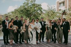 a group of people standing next to each other on a wooden floor in front of trees