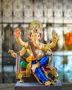 a statue of an elephant sitting on top of a wooden table next to a wall