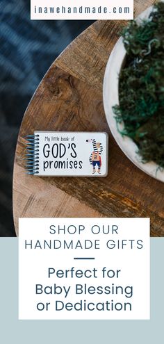 a wooden table topped with a white plate filled with green seaweed next to a sign that reads, shop our handmade gifts perfect for baby blessing or dedication