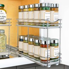 an open spice rack in a kitchen filled with spices and condiments next to a bottle of olive oil