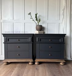 two black dressers side by side on wooden floors with white walls and wood flooring