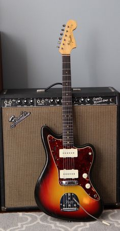 an electric guitar sitting on top of a table next to a speaker and other musical equipment