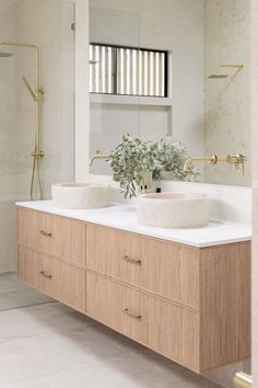 two white sinks sitting on top of a wooden counter