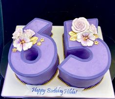 a purple birthday cake with flowers on it