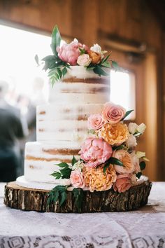 a wedding cake decorated with flowers on a table