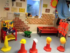 a room filled with lots of toys and construction hats on the floor next to each other