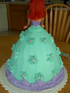 a cake shaped like a princess sitting on top of a table