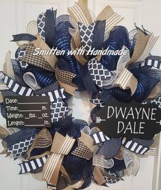 a blue and white wreath with black and tan ribbons