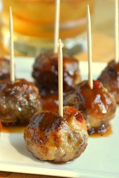 small meatballs with toothpicks on a white plate