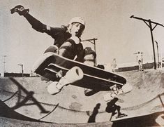 a man riding a skateboard up the side of a ramp at a skate park