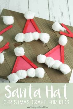 santa hat craft for kids made out of paper and cotton balls on a wooden board