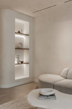 a living room filled with white furniture and shelves on the wall next to each other