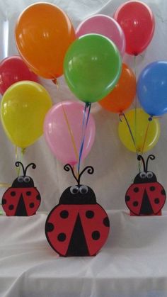 three ladybug shaped balloons are in front of each other