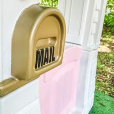 a mailbox with the word mail on it is next to a pink and white door