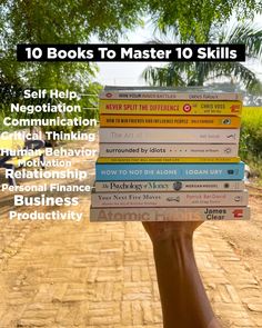 a person holding up a stack of books in front of their face with the title 10 books to master 10 skills