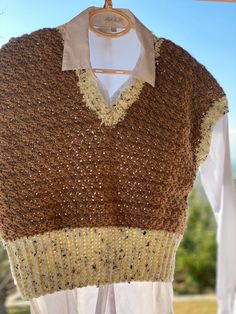 a brown and white sweater hanging on a clothes rack