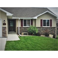 a house that has grass in front of it and two garages on the other side